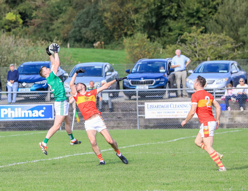 Ballincollig's Cian Dorgan outjumps Éiré Óg's Michael Corkery. Picture: David Creedon