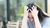Sad woman complaining alone sitting on a coffee shop terrace