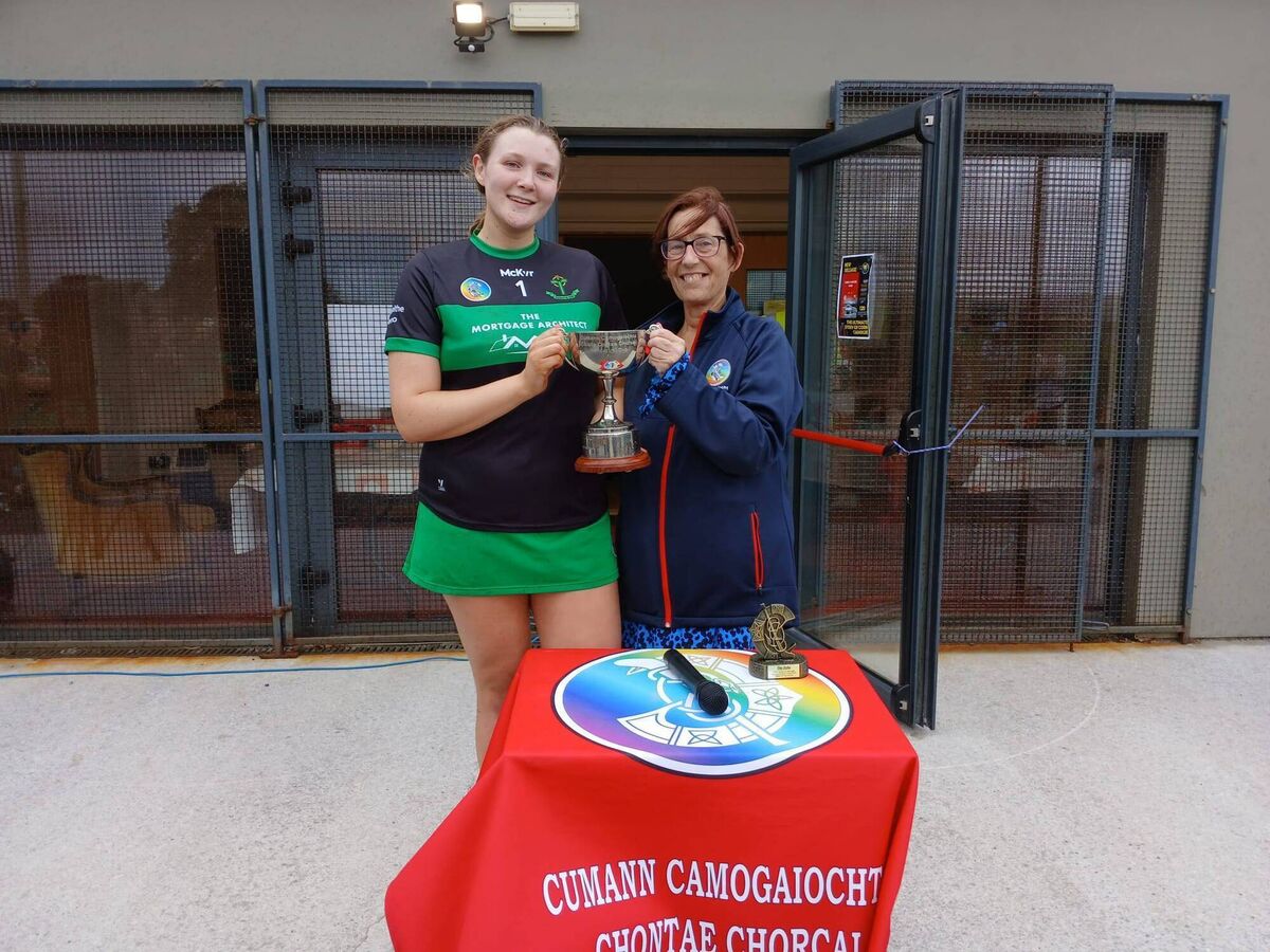 Cork Camogie chair Máiréad O Donovan hands over the trophy to Nemo Rangers captain Megan O'Donovan after the SE Systems Junior C final.