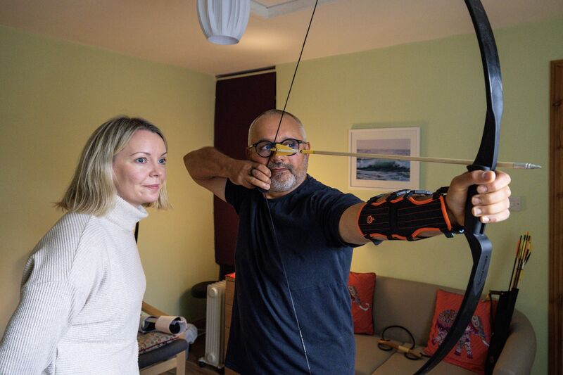 Toufik Messabih, Psychotherapist guides Emer Harrington through an indoor archery session in his home office in Carrigaline. Picture Chani Anderson