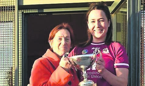 Jennifer Ryall, Bishopstown captain, is presented with the S E Systems Junior A Championship cup by Máiréad O’Donovan, Cork Camogie board.
