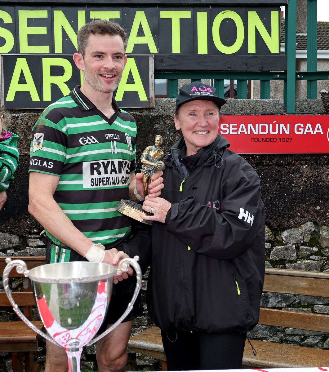 Barry Fitzgerald, Douglas, receives the Player of the Match Trophy from Jess O'Sullivan, AOS Security. Barry Fitzgerald, Douglas, receives the Player of the Match Trophy from Jess O'Sullivan, AOS Security.