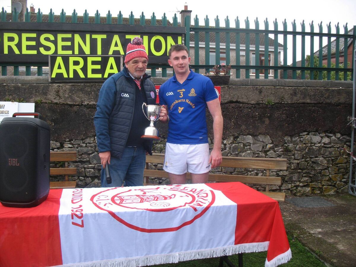 Seandún chairman Michael Buckley presenting the AOS Security Seandún Junior B Hurling Championship trophy to St Finbarr's captain JJ O'Connor. 