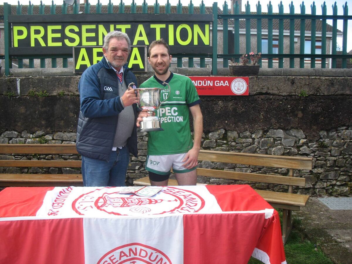 Seandún Chairman Michael Buckley presents the Seandún Junior C Championship trophy to White's Cross winning captain Richie Sherlock