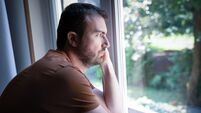 Portrait of one guy feeling sad and looking through window