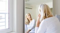 Senior woman sitting in front of mirror