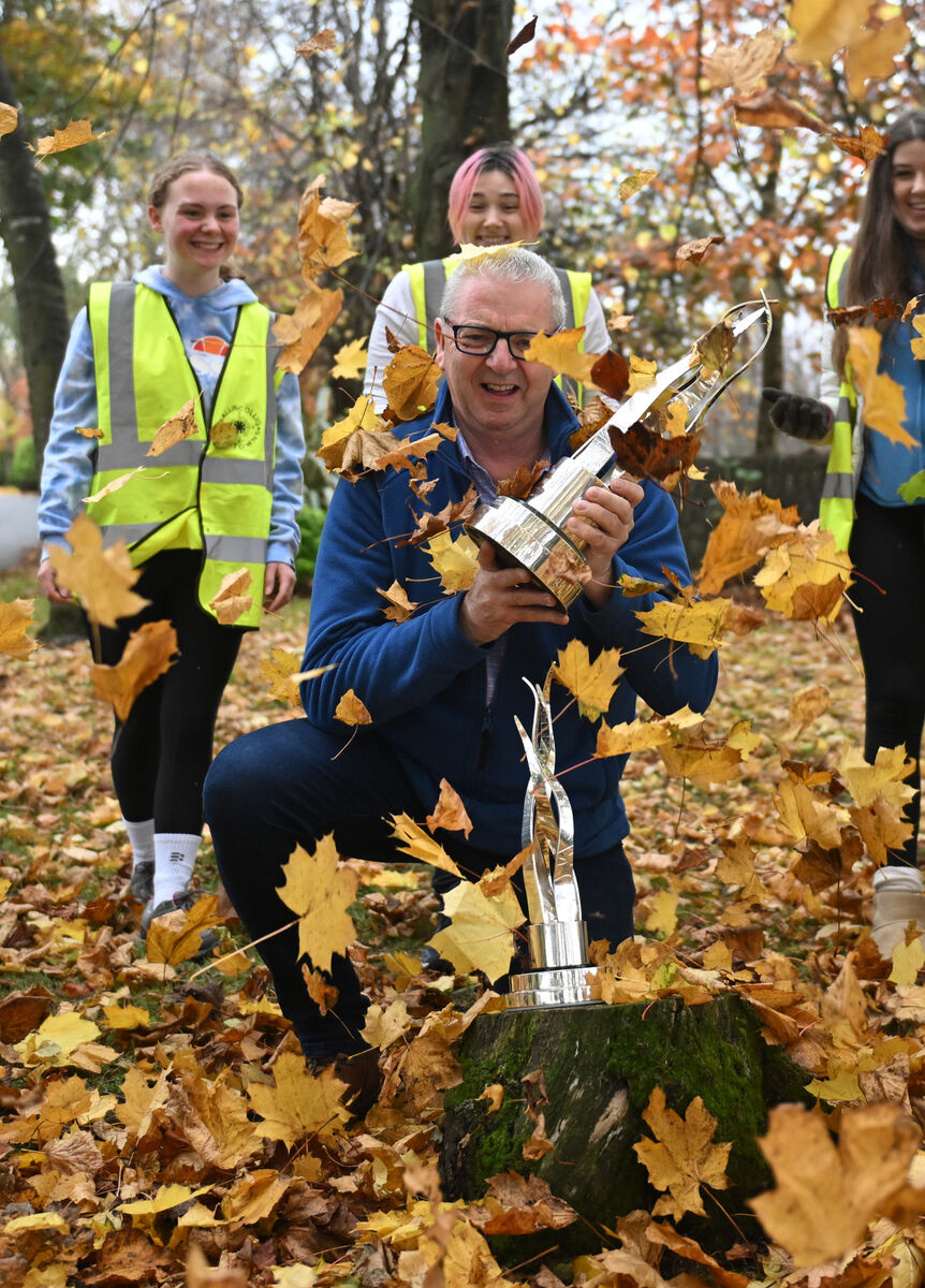  Ballincollig Tidy Towns Chairman Tom Butler with the SuperValu National Tidy Towns Gold Medal Winner trophy and Ireland’s Tidiest Large Urban Centre trophy as he gets covered with leaves by the TY students helping out with the work. . Picture Dan Linehan