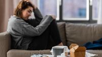 stressed woman sitting on sofa at home