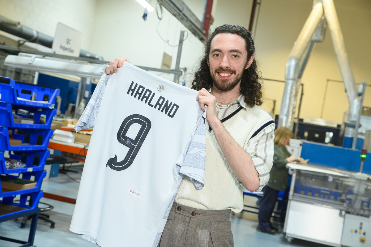 Graphic designer Frank Curtin holding the Manchester City Year of the Dragon jersey he designed at Elms Marketing Ireland in Kinsale.