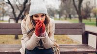 Depression and loneliness. Woman in trouble sitting on bench in autumn park crying covering face with hands. Mental health
