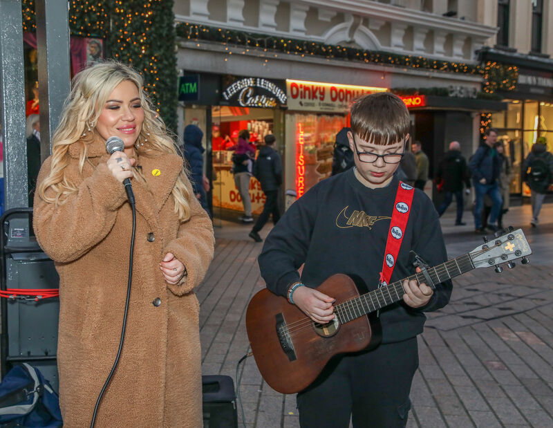 Mel McCarthy is accompanied by her son Kai on guitar as they perform during the annual busking marathon to raise funds for Penny Dinners on Patrick Street, Cork. -Picture: David Creedon
