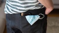 Medical face mask and smart phone in trouser back pocket. Concept for the new normal life after COVID-19 Coronavirus pandemic. C
