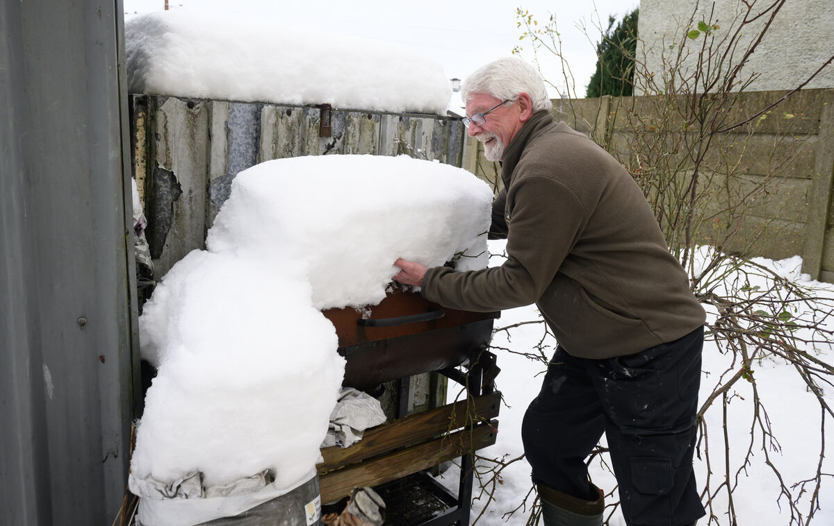 Billy Morrison clearing two feet of snow from the BBQ at his home in Charleville, Co Cork. Picture: Dan Linehan Billy Morrison clearing two feet of snow from the BBQ at his home in Charleville, Co Cork. Picture: Dan Linehan