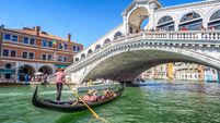 Gondola with tourists on Gran Canal with Rialto Bridge, Venice