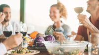 Happy friends eating vegetarian food and drinking red wine - Vegan family dining fresh vegetables in farmhouse