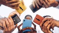 Teens in circle holding smart mobile phones - Multicultural young people using cellphones outside - Teenagers addicted to new te