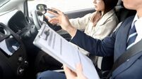 A woman and a male instructor during driving lessons