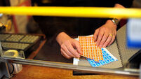 the hands of post office counter staff sorting and selling stamps at in a local post office in Bridestowe, Devon, UK.. Image sho