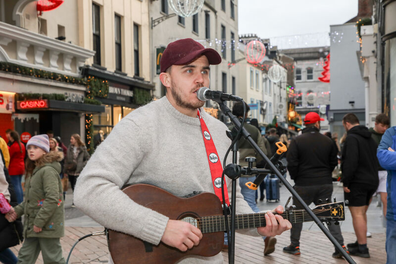 Cathal Fitz performs during the annual busking marathon to raise funds for Penny Dinners on Patrick Street last Christmas. Picture: David Creedon
