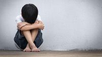 A boy sitting alone with sad feeling. Asian little child covered his face with his hands in fear.  Domestic Family violence conc