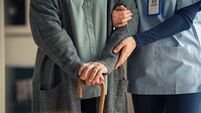 Nurse assisting senior with walking cane