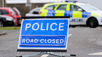 Police road closed sign with police car blocking the road