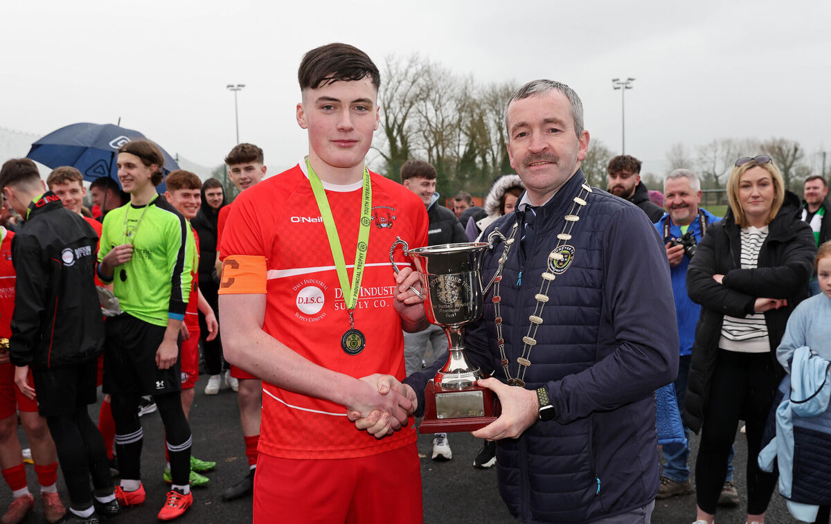  Kealan Crowe, Cork Youth League Captain, receives the Cup from John Buckley, Chairperson Munster FA.