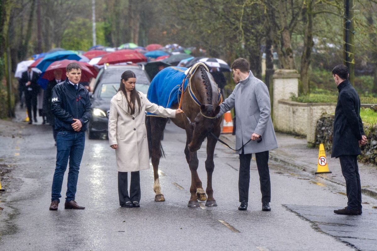 The hearse carrying Jockey Michael O’Sullivan is lead by one of his beloved horses from St John’s Baptist Church to his final resting place in St. John’s cemetery in Glantane, Co Cork. Picture Chani Anderson
