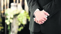 man or mortician at funeral mourning