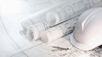 Hard hat and compass on architectural blueprints and construction technology and future industry