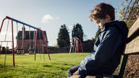 Lonely child sitting on play park playground bench