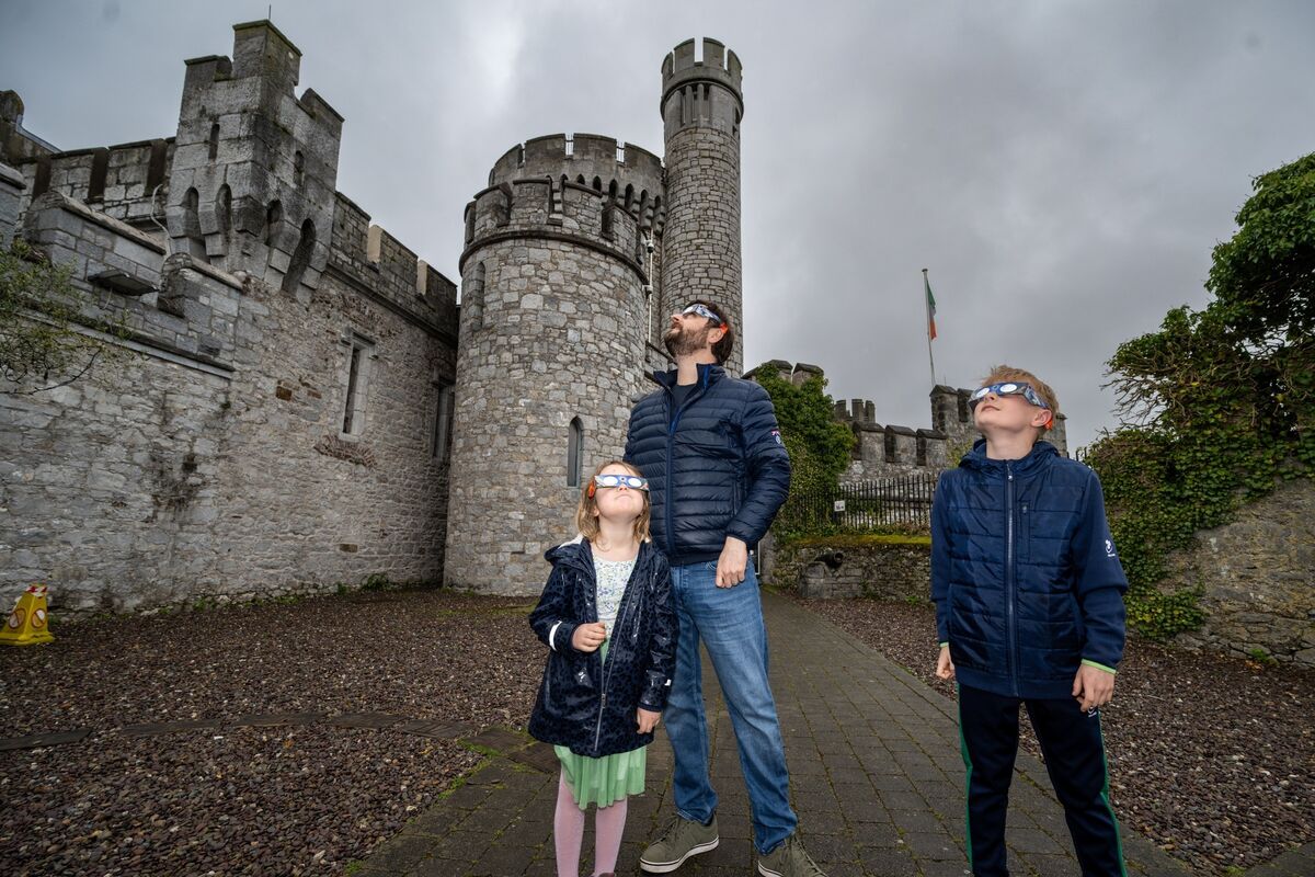 Evie Buckley (5), pictured with her father David, and brother Cillian (11) join eclipse watchers at Blackrock Castle Observatory, hopeful for a glimpse of the sun through the overcast sky. Picture Chani Anderson