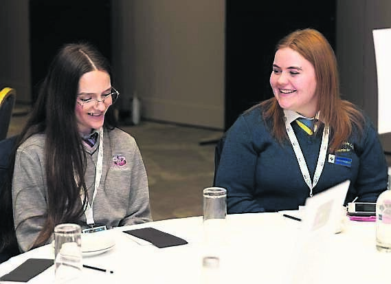 Amelia Ní Reen Ní Mhathúna, ar chlé, Coláiste Daibhéid, cathair Chorcaí ag roinnt tuairimí le Erin Ní Laoi, Coláiste Cois LIfe, Leamhchán, Co Baile Átha Cliath le linn Muintearas'25. Griangraf: Seán Ó Mainnín