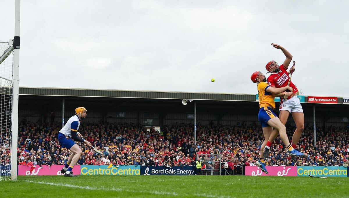 Brian Hayes of Cork attempts to palm the sliotar to the net as he is tackled by Darragh Lohan of Clare. Picture: Brendan Moran/Sportsfile