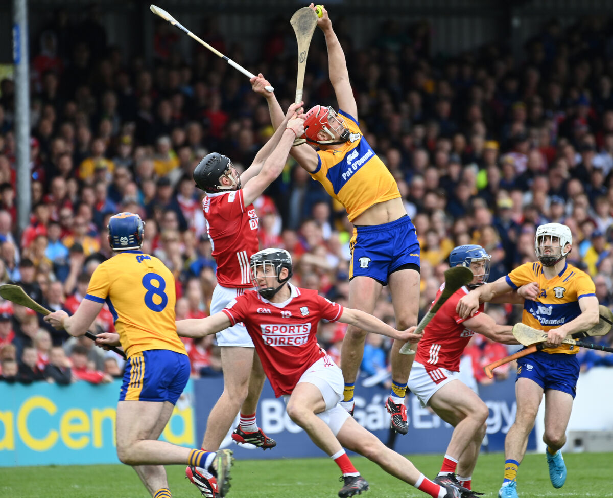 Clare's Peter Duggan soars into the air to win the sliotar from Cork's Eoin Downey. Picture: Eddie O'Hare