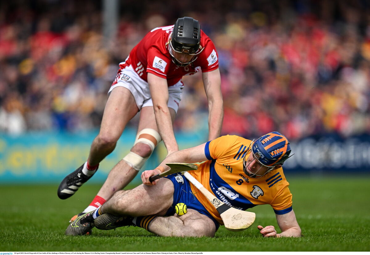 David Fitzgerald of Clare holds off the challenge of Robert Downey of Cork. Picture: Brendan Moran/Sportsfile