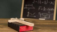 A crucifix on a book against the background of a chalkboard