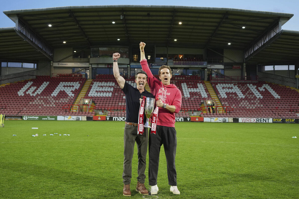 Wrexham co-owners Rob McElhenney, left, and Ryan Reynolds pose with trophy. Picture: AP Photo/Jon Super