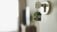 Open the door and door handle with a key and a keychain shaped house. Property investment and house mortgage financial real esta