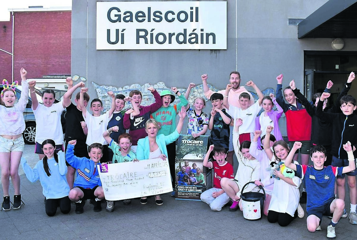 Fourth class pupils at Gaelscoil Uí Ríordáin, Ballincollig, celebrate as they present €2,375, the proceeds of a number of fundraising events, to Trócaire’s Janet Twomey.	Picture: Mike English
                    