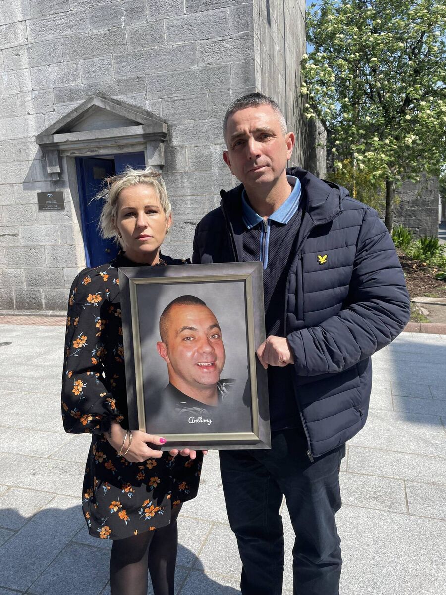 The late Anthony Hennessy's wife, Melissa and his brother, Kenneth, hold a framed photograph of him following the inquest into his death. 