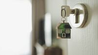 Open the door and door handle with a key and a keychain shaped house. Property investment and house mortgage financial real esta