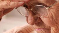 Senior woman with headache at home, closeup. Symptom of age-related memory impairment