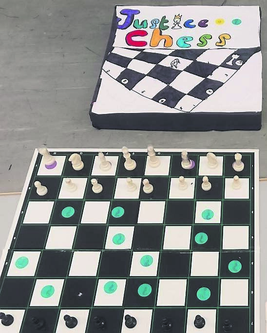 Third class pupils at Scoil Eoin, Innishannon, with their teacher Eilís Ní Ríain - the school also got its latest Green Flag last week. RIGHT: The game of Justice Chess invented by the class