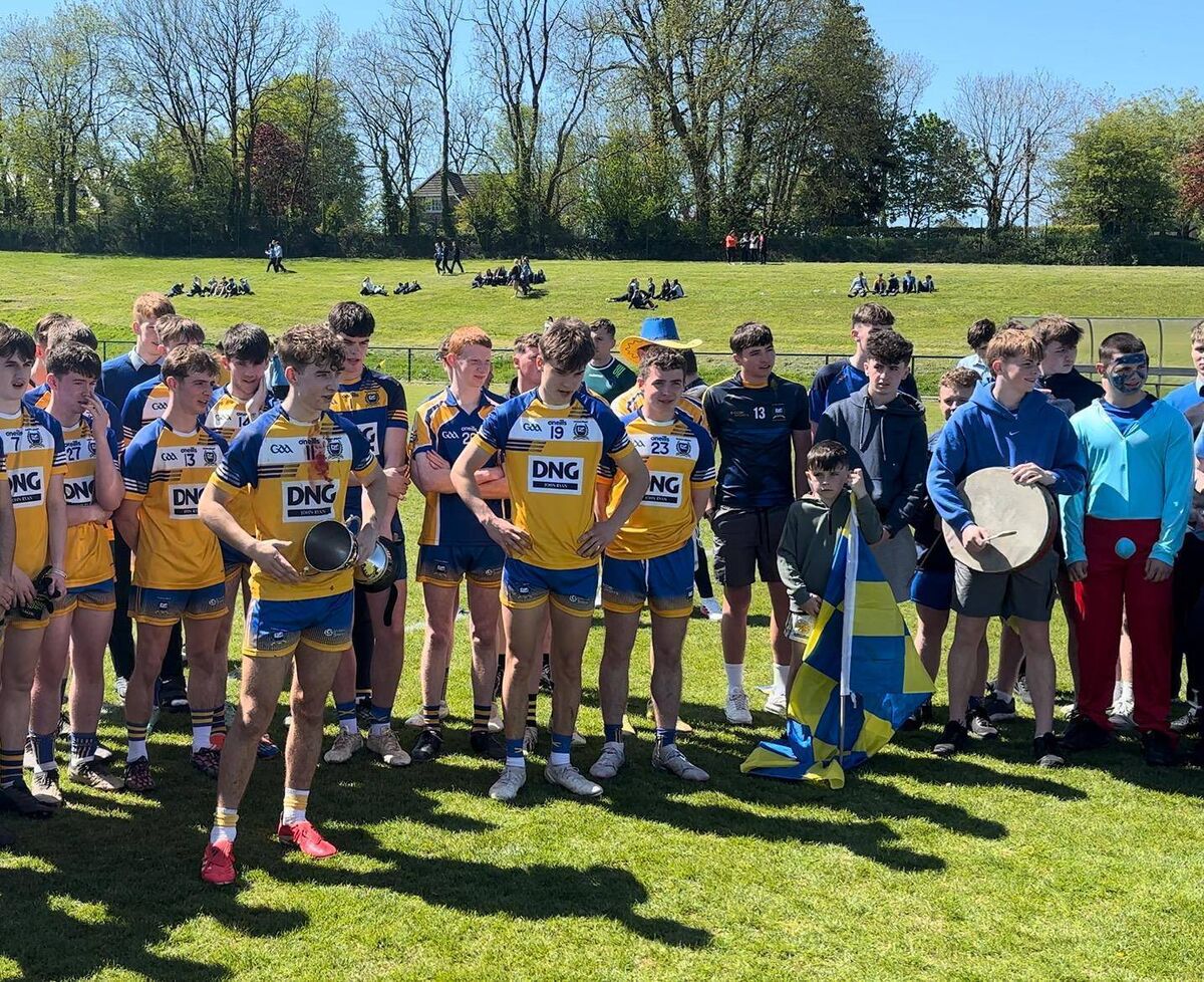 Coláiste Mhuire captain Oier O’Callaghan accepts the trophy on behalf of the team.