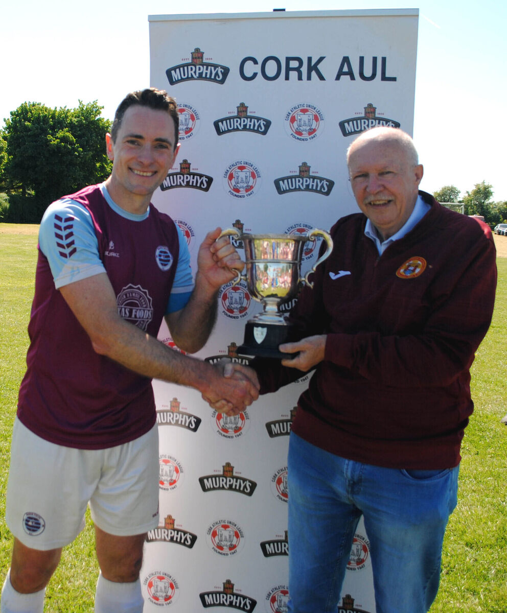 Boher Celtic's Dan O'Connell is presented with the League 2 trophy by Martin Conlon (Chairperson of the Cork AUL).