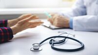 medical consultation - doctor talking to patient in clinic office. focus on stethoscope