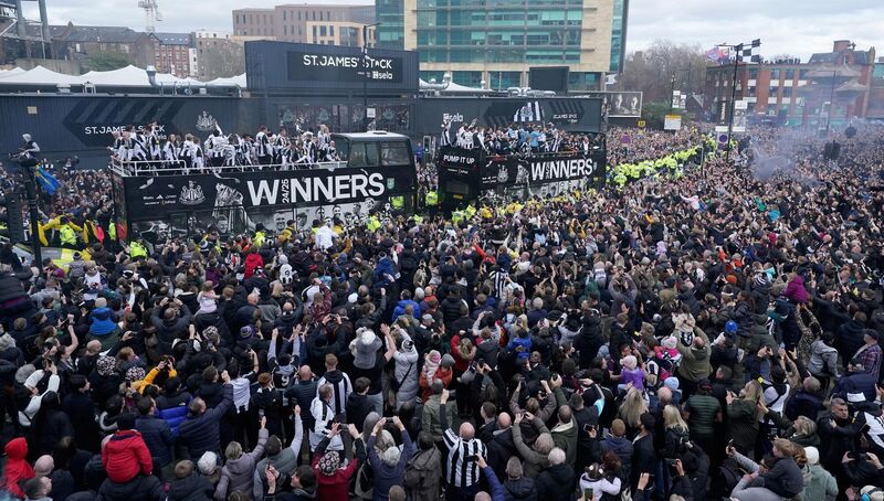 The open top buses carrying the Newcastle United players passes by fans outside St James' Park, during the Carabao Cup trophy parade in Newcastle. Picture: Owen Humphreys/PA Wire.