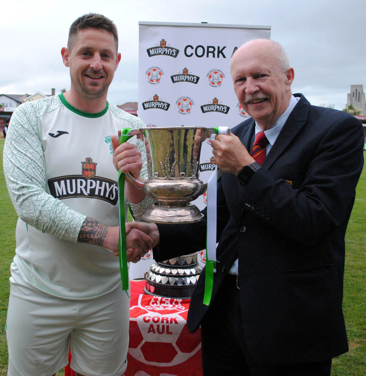 Martin Conlon (Chairperson of the Cork AUL) presents the AOH Cup to Coachford FC's captaiin Stephen Murray.