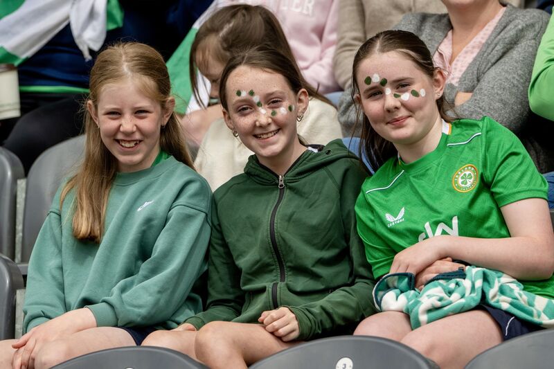  Three young Innishannon supporters smile brightly from the stands with colourful face paint as they cheer on their team during the Allianz Sciath na Scol Cork DH2 final against GS Uí Drisceoil. Picture: Chani Anderson.